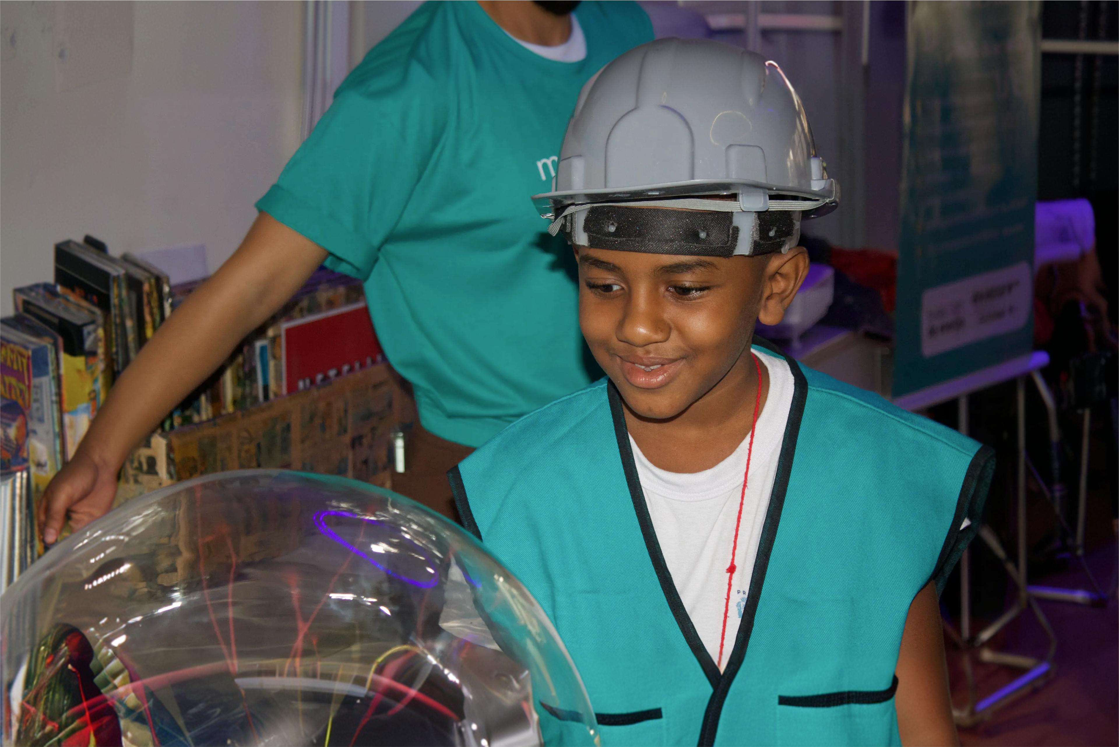 Criança com capacete da Light interagindo com globo de plasma no museu